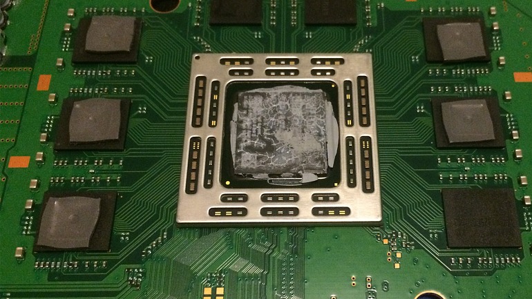 Procesador de una PS4 con la pasta térmica de serie, algo deteriorada. Ha sido necesario desmontar completamente la consola para poder sustituirla. Procesador de una PS4 con la pasta térmica de serie, algo deteriorada. Ha sido necesario desmontar completamente la consola para poder sustituirla.